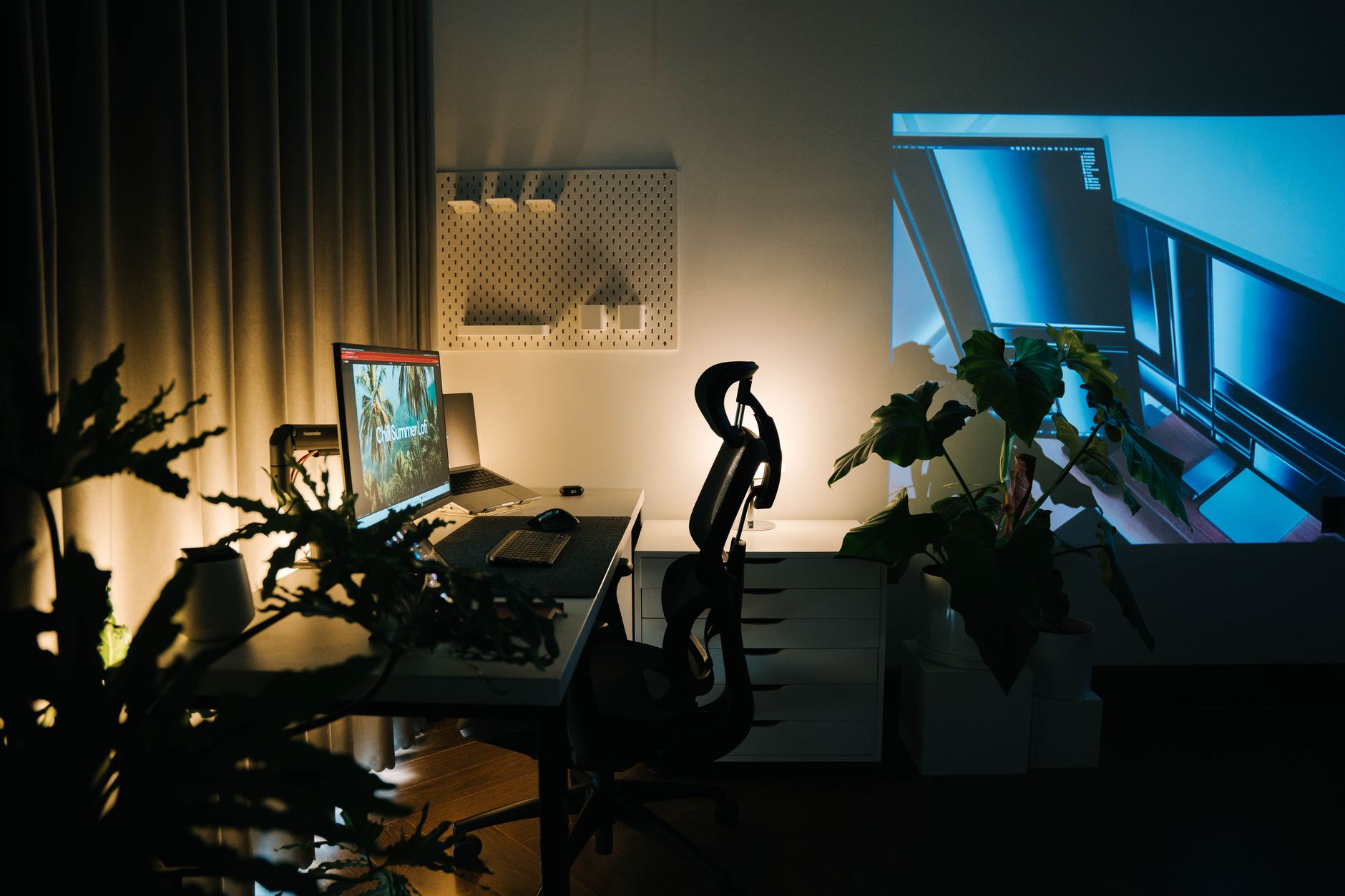 Hyggeligt hjemmekontor med planter og ambient belysning, indrettet til roligt skrivearbejde.